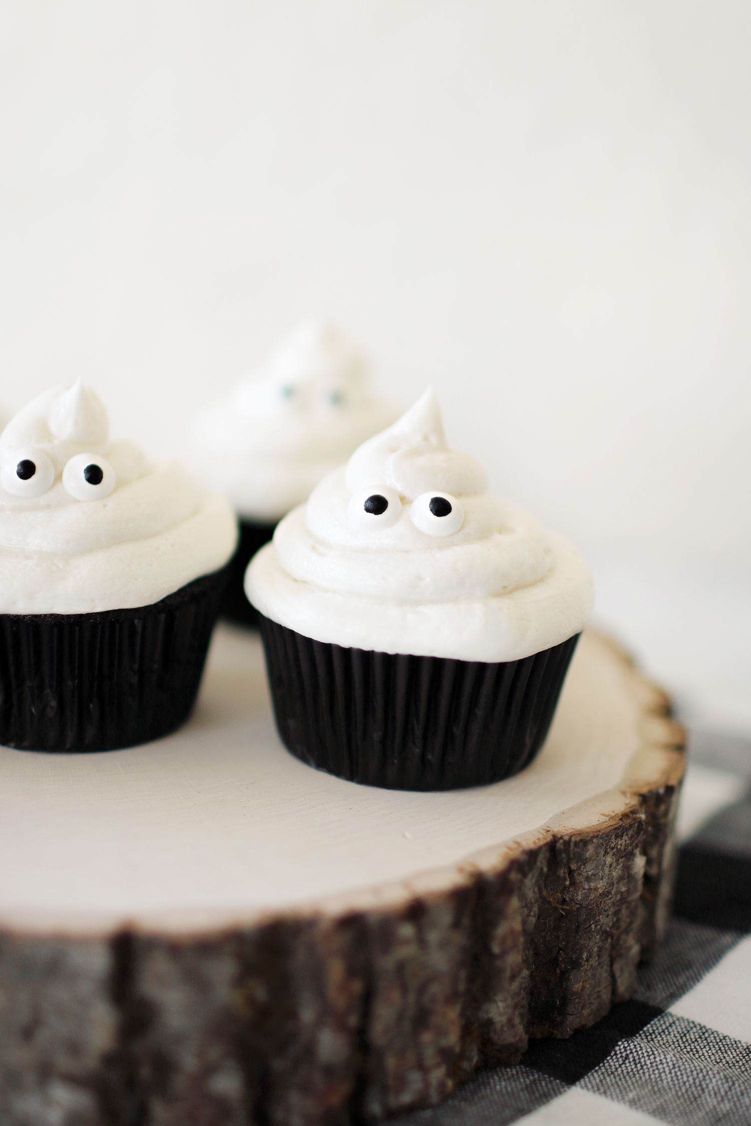 Black velvet and vanilla butter cream ghost cupcakes that our family loves to make for the Halloween festivities. Simple recipes and easy decorating make these cupcakes a hit for anyone who gets to make them. They are also delicious for all who get to enjoy them. Catch the entire recipe for our Ghost in the Graveyard cupcakes over at Haus of Layne! #HalloweenFood #HalloweenRecipe #HalloweenFoodIdeas #HalloweenTreats #Cupcakes #CupcakeRecipe #ButtercreamFrosting #BlackVelvetCake 