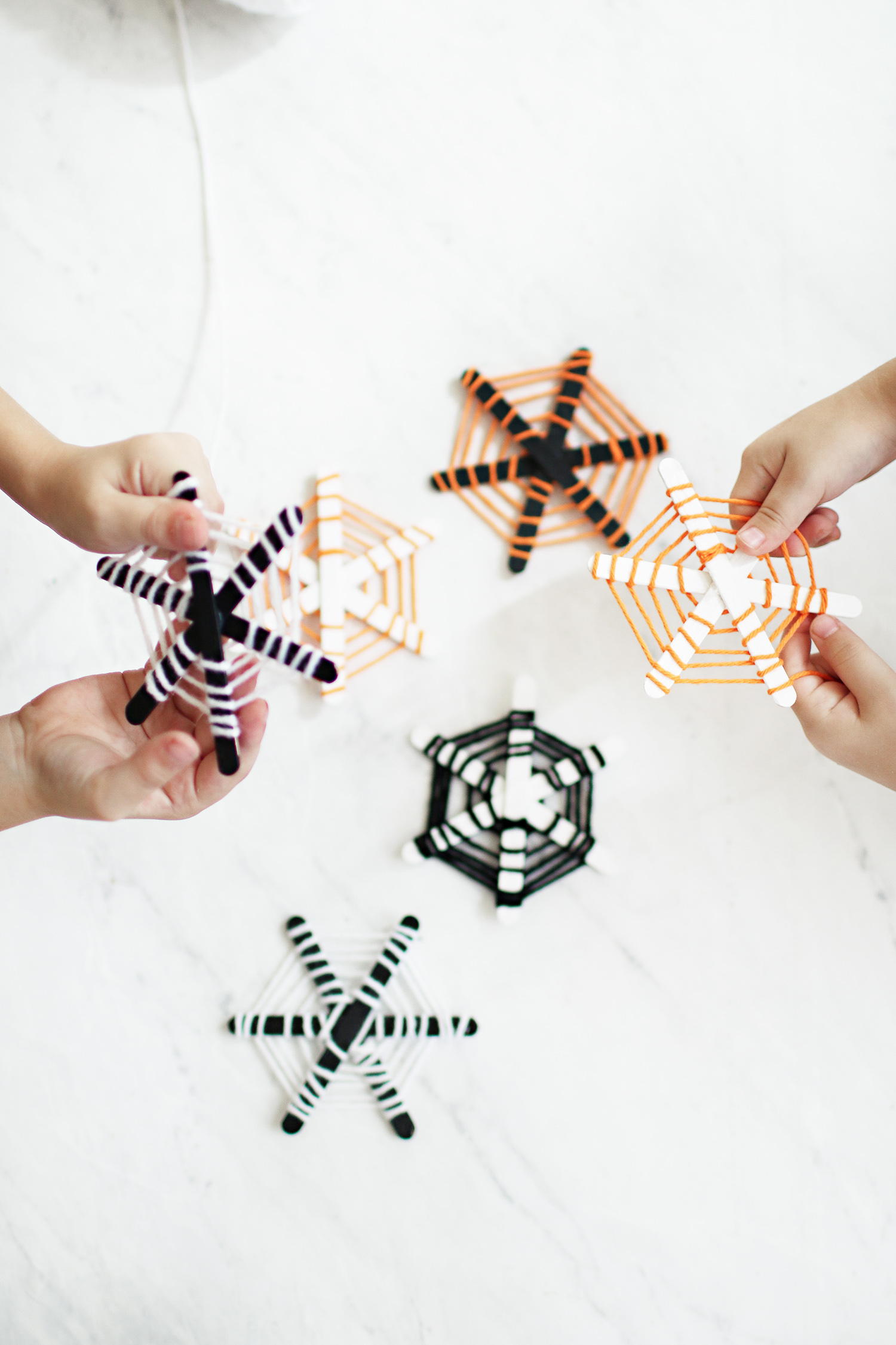 Halloween craft for the kids and these DIY Popsicle stick spiderwebs are the cutest! Our kiddos love hanging them up each year over our kitchen table. Catch the walk through over at Haus of Layne! #Halloween #HalloweenCraft #KidsCraftIdeas #HalloweenDecorIdeas #HalloweenIdeas