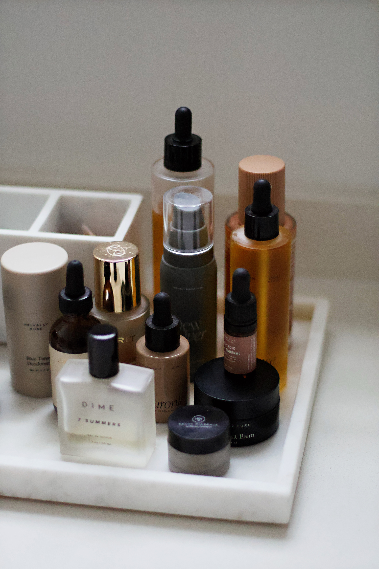 Simple bathroom organization featuring skincare products displayed on a white marble tray.