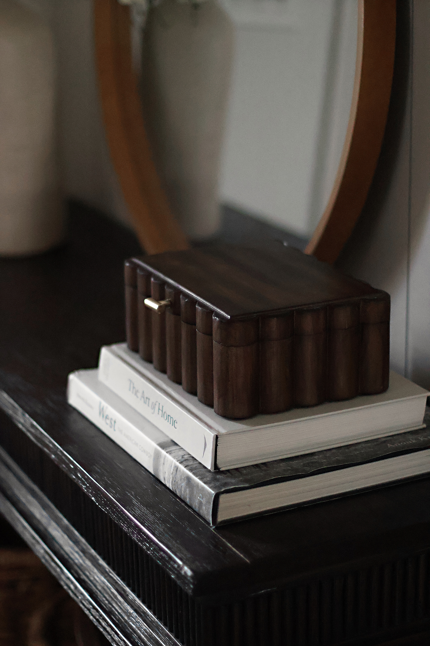 Decorative wooden box styled on coffee table books in a warm, neutral home interior.