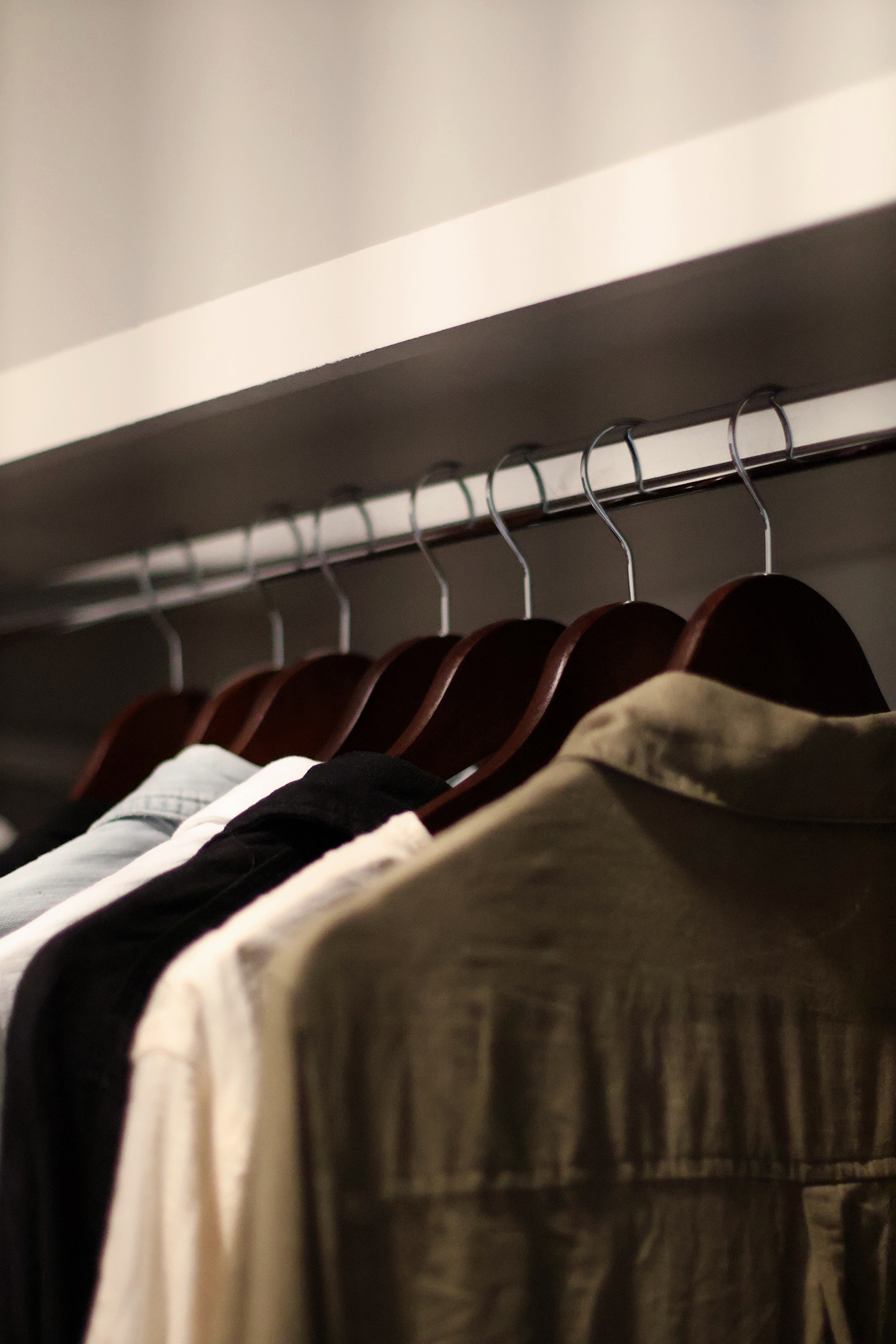Matching wooden hangers creating a clean, organized closet with a simple and cohesive look.